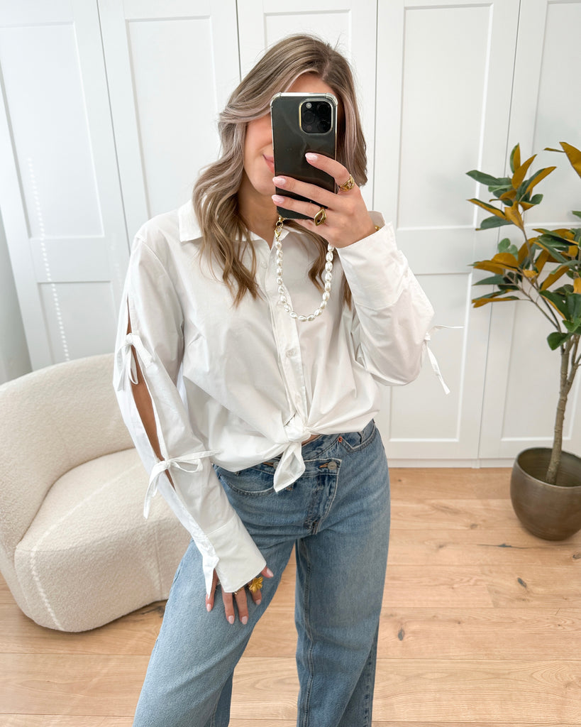Witte lange blouse met strikjes op de mouwen