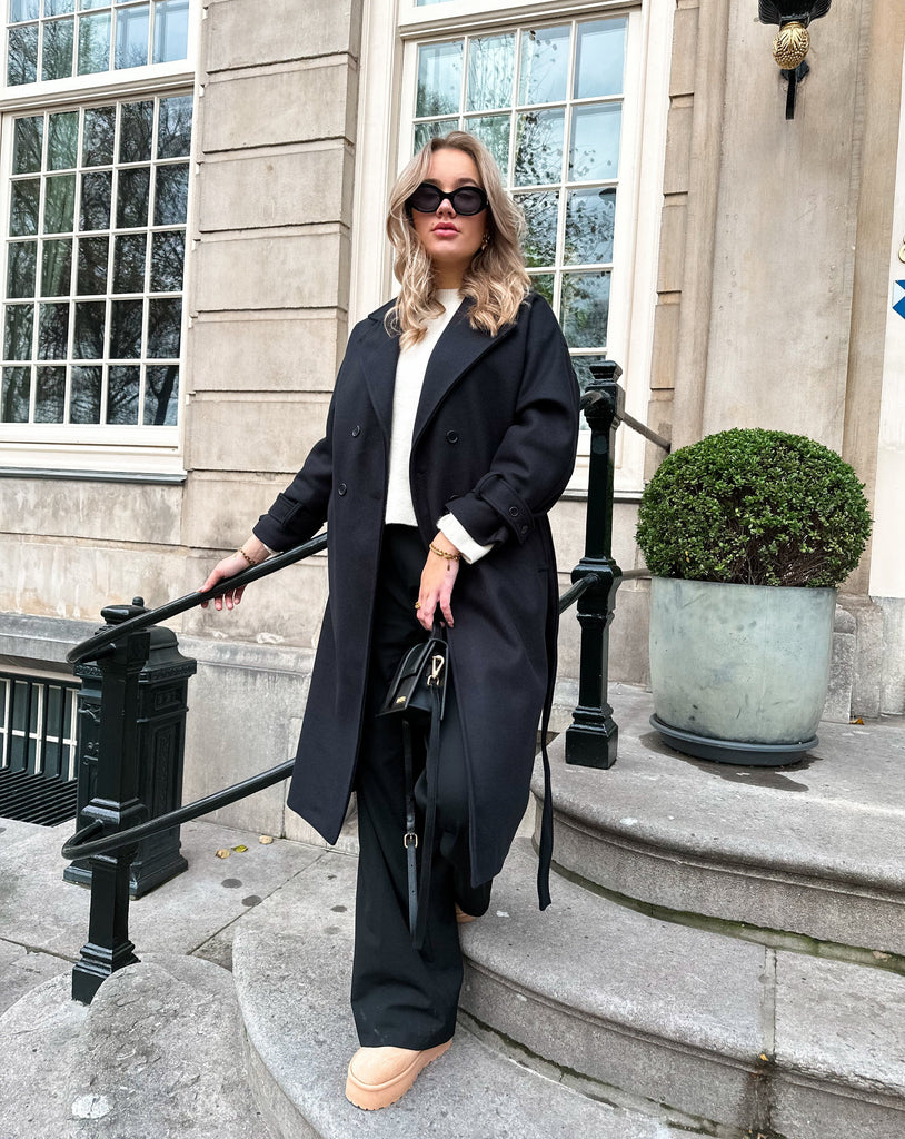 Zwarte lange trench coat met knoop sluiting en strik detail