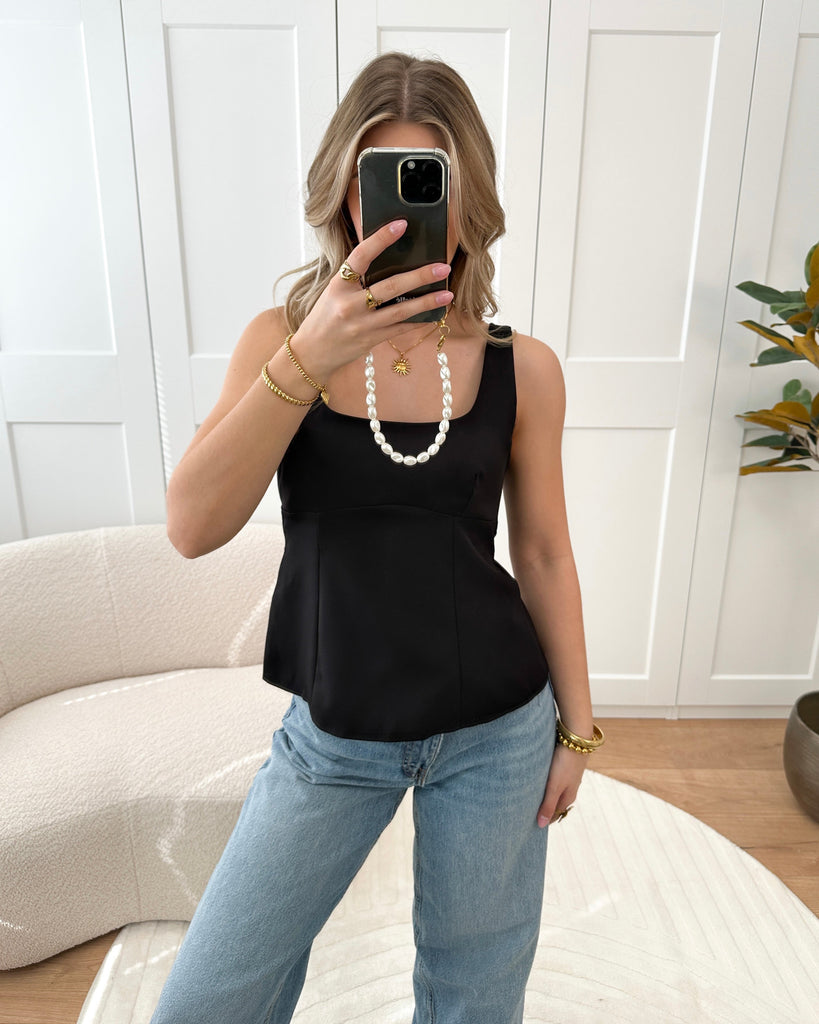 Zwarte peplum top met strik detail op de rug