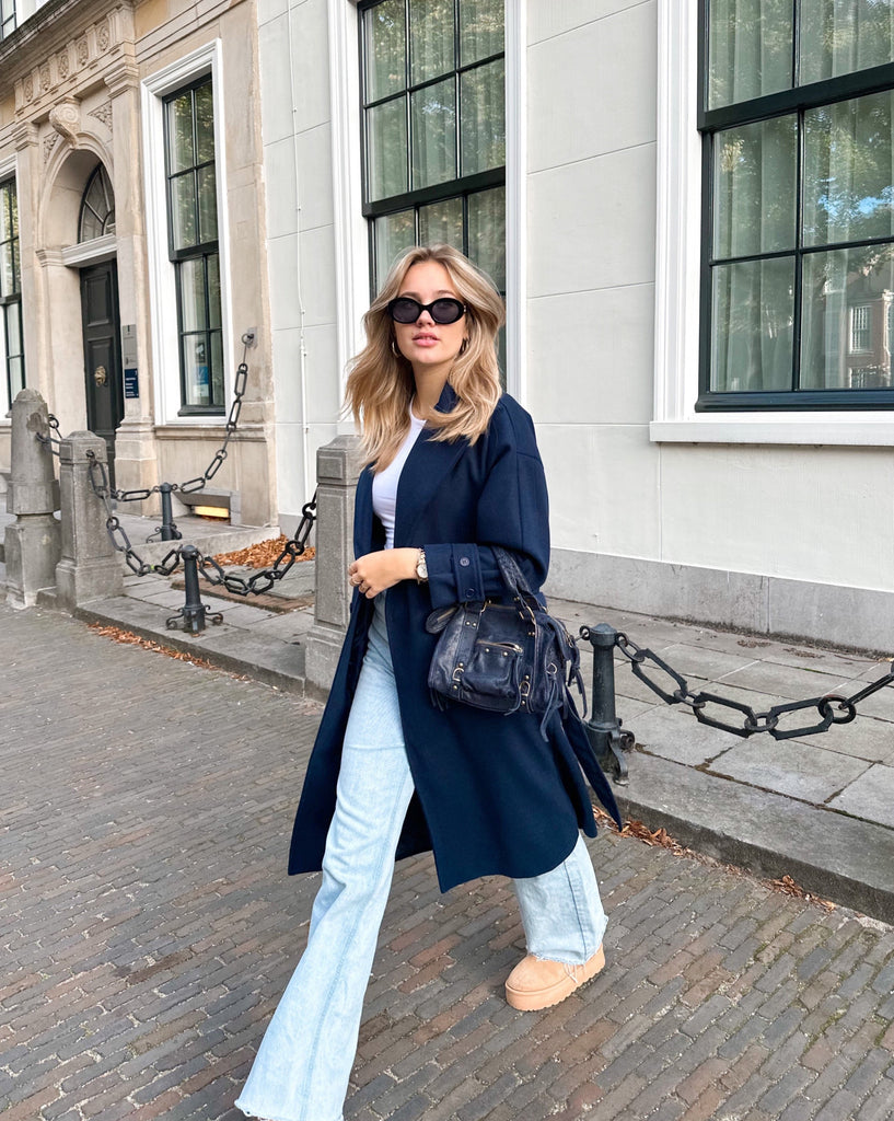 Donker blauwe lange trench coat met knoop sluiting en strik detail