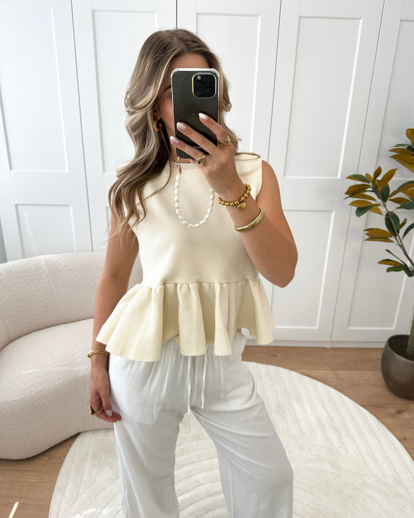 Creme mouwloze peplum top
