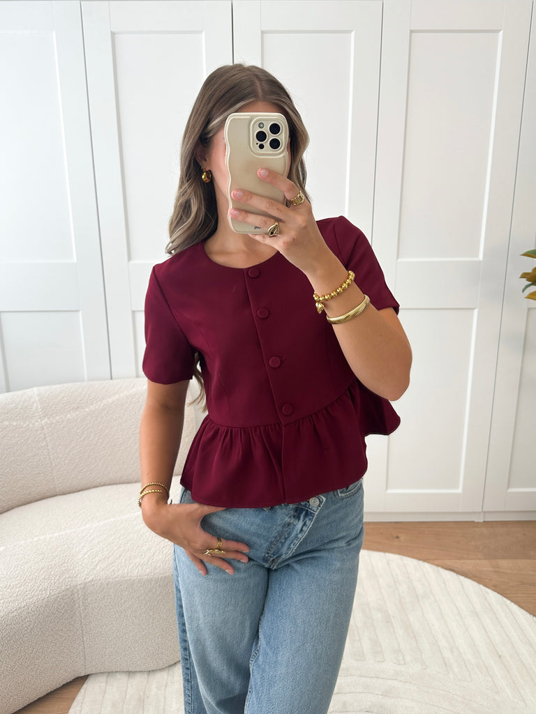 Bordeaux rode top met korte mouwen en knoopsluiting met peplum effect