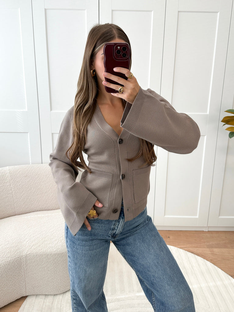 Taupe vest met knoopsluiting, v-hals, zakjes aan de voorzijde en wijduitlopende mouwen