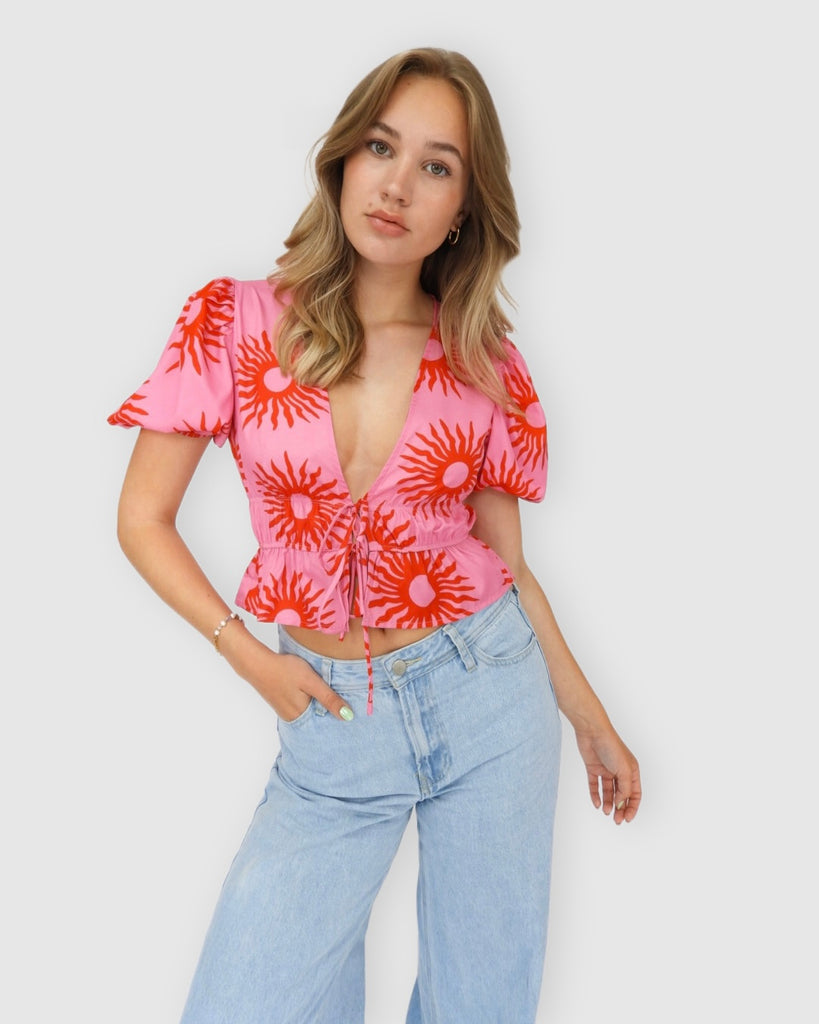 Roze topje met strikjes en rode zonnetjes, rood printje