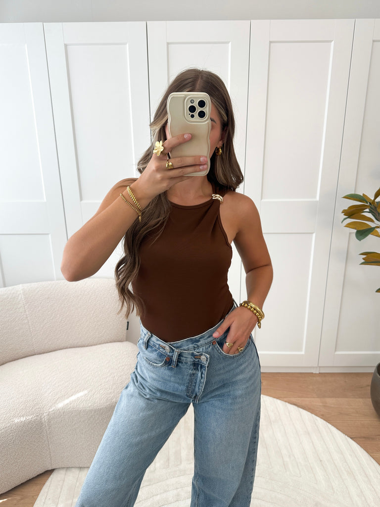 Bruine mouwloze body met gouden knoopdetail op de schouder