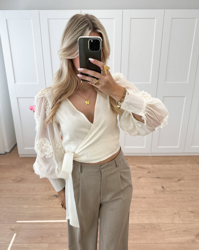 Ecru blouse met strik detail en bloemen op de mouwen