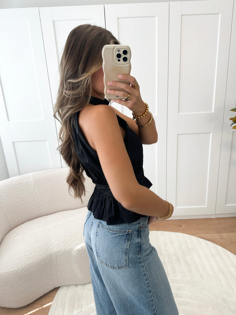 Zwarte halter top met gouden knoop en peplum effect
